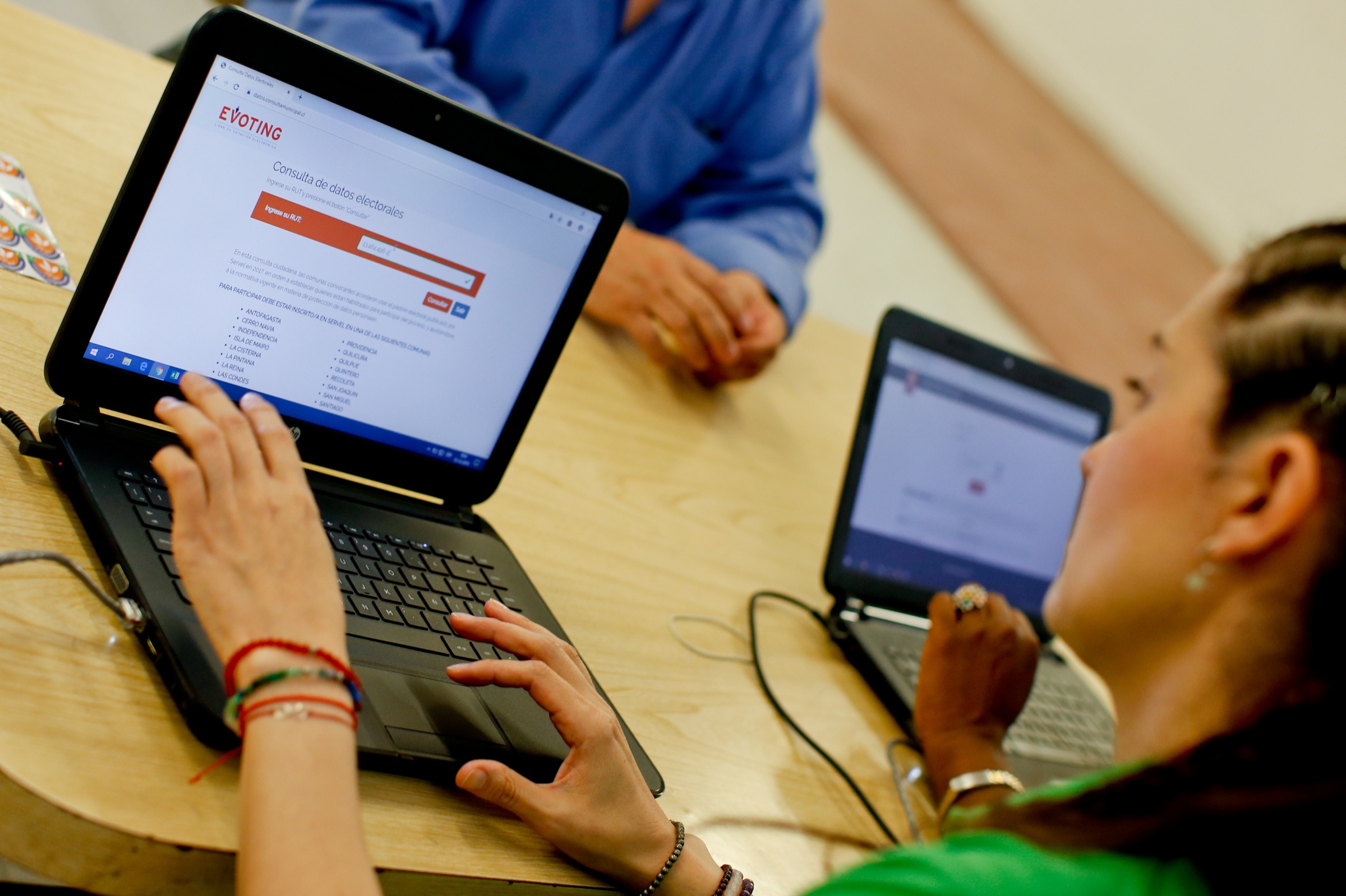 Mujer frente a computador votando en la plataforma de votación electrónica de EVoting