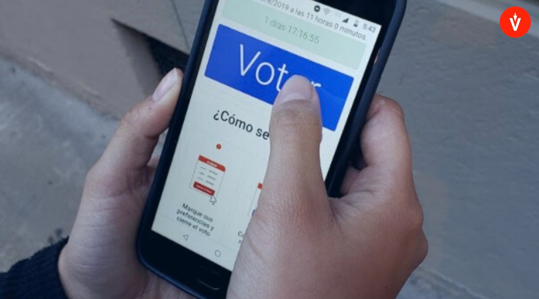 Persona sosteniendo teléfono celular que muestra plataforma de votación electrónica de EVoting